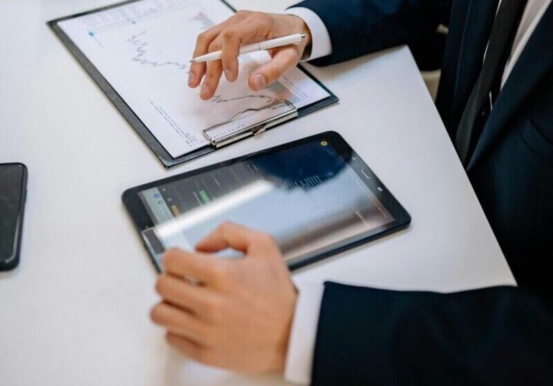 Business professionals working with tablet and documents in a modern office.