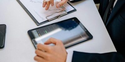 Business professionals working with tablet and documents in a modern office.