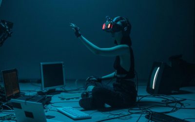 Woman immersed in virtual reality, surrounded by tech, in a dimly lit room.