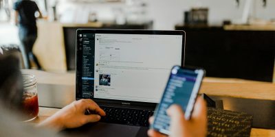 person using phone and laptop