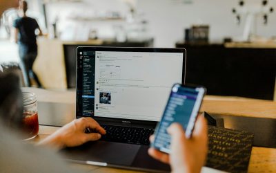 person using phone and laptop