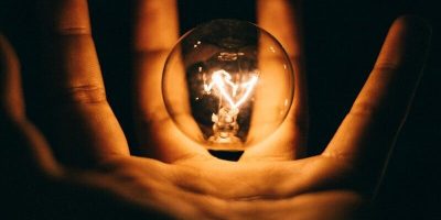clear glass bulb on human palm